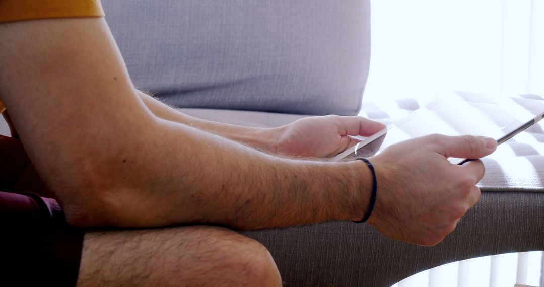 Man Relaxing on Sofa Holding Digital Tablet - Free Images, Stock Photos and Pictures on Pikwizard.com