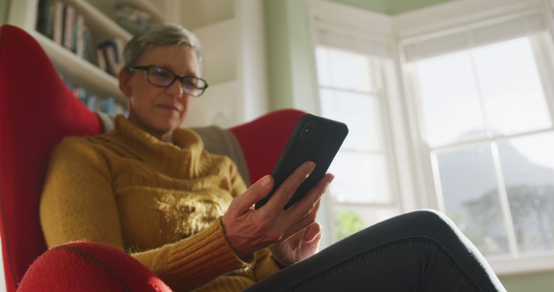 Senior Woman Enjoying Smartphone in Cozy Living Room - Free Images, Stock Photos and Pictures on Pikwizard.com