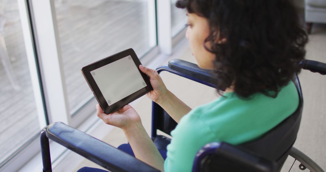 Woman in Wheelchair Using Tablet by Window Indoors - Free Images, Stock Photos and Pictures on Pikwizard.com