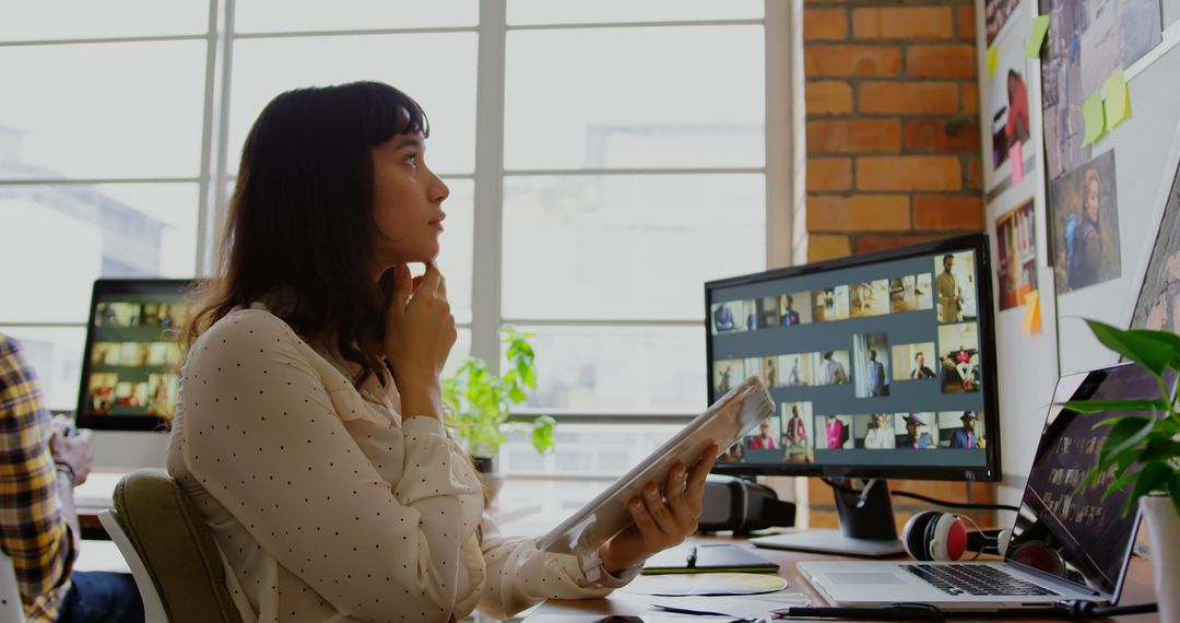 Thoughtful Female Graphic Designer Sitting in Modern Office
