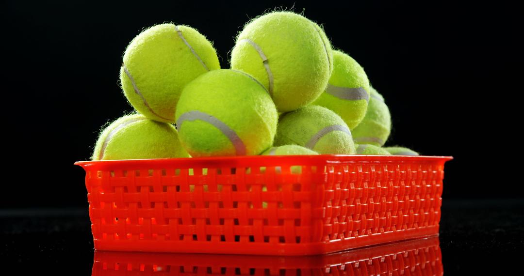 Close-Up of Tennis Balls in Red Basket on Black Background - Free Images, Stock Photos and Pictures on Pikwizard.com