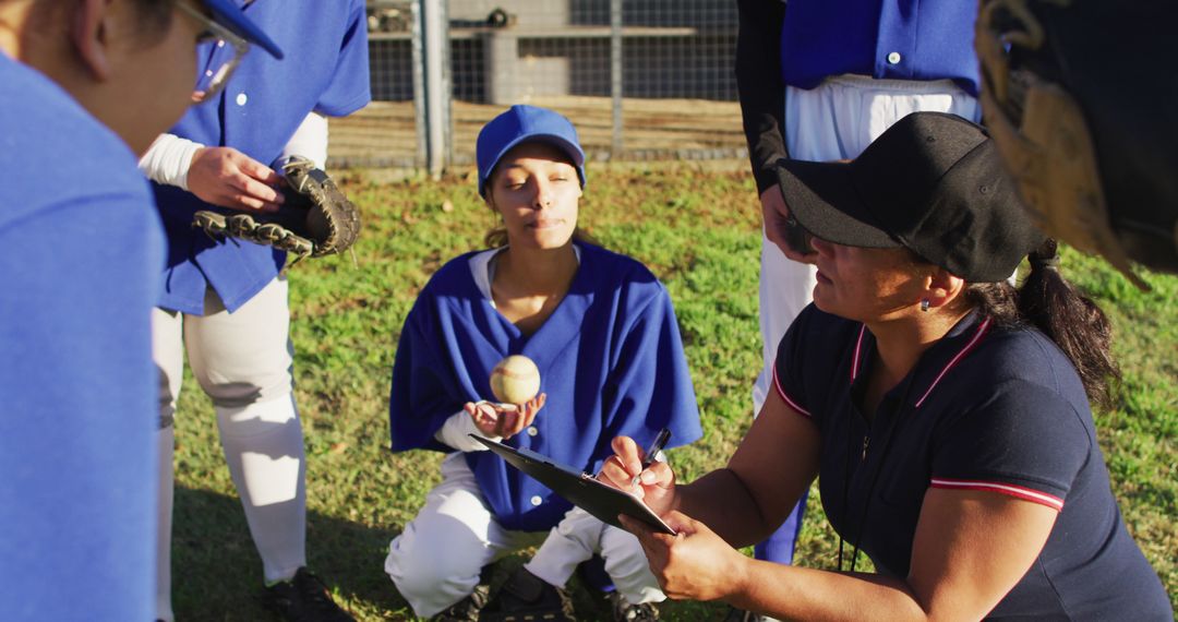 Female baseball coach giving instructions to young players on sunny day - Free Images, Stock Photos and Pictures on Pikwizard.com