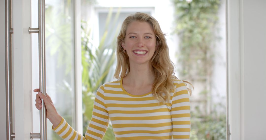 Smiling Woman in Light-Filled Room Wearing Yellow Striped Sweater - Free Images, Stock Photos and Pictures on Pikwizard.com