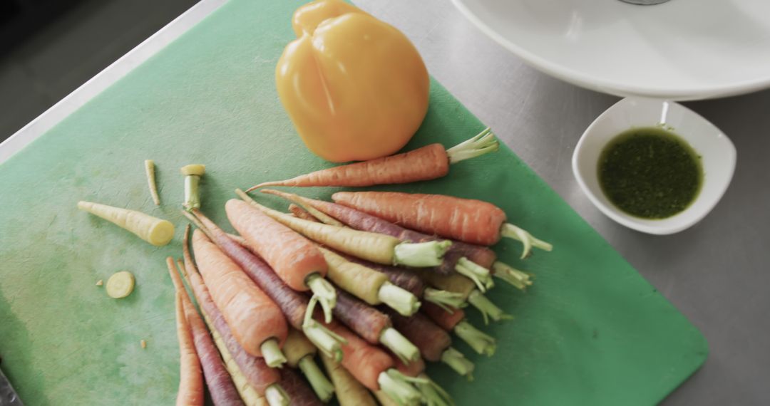 Colorful Carrots with Yellow Bell Pepper and Herb Sauce on Cutting Board - Free Images, Stock Photos and Pictures on Pikwizard.com