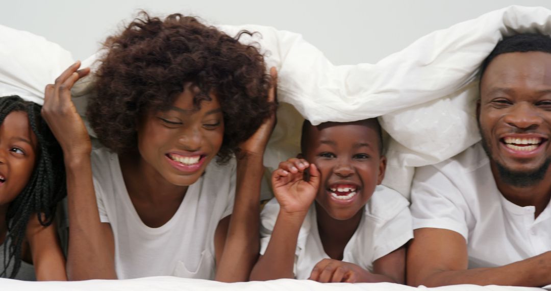 Happy African-American Family Laughing Under Blanket - Free Images, Stock Photos and Pictures on Pikwizard.com