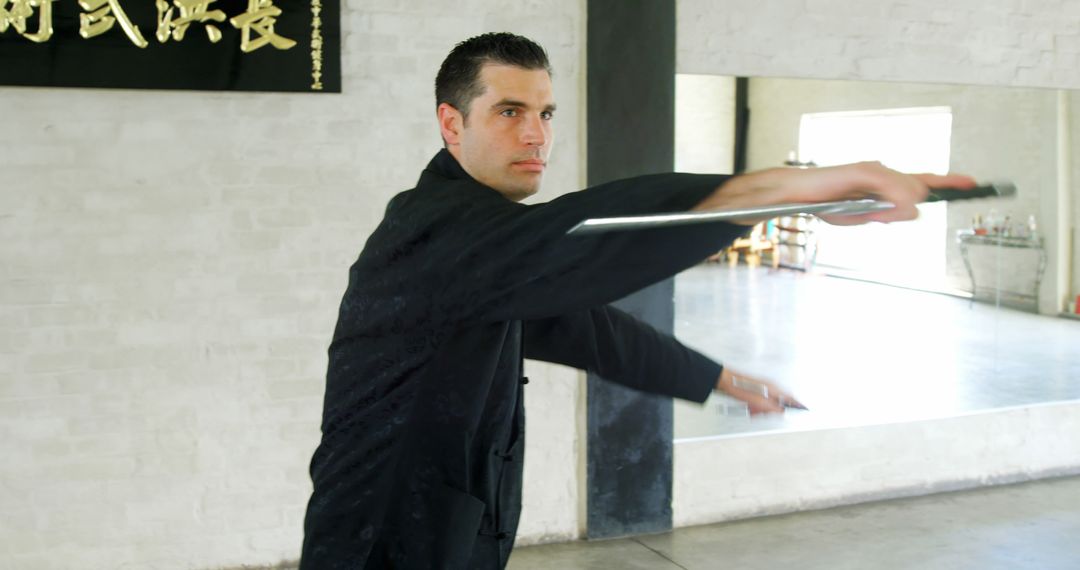 Man Practicing Martial Arts with Swords in Dojo - Free Images, Stock Photos and Pictures on Pikwizard.com