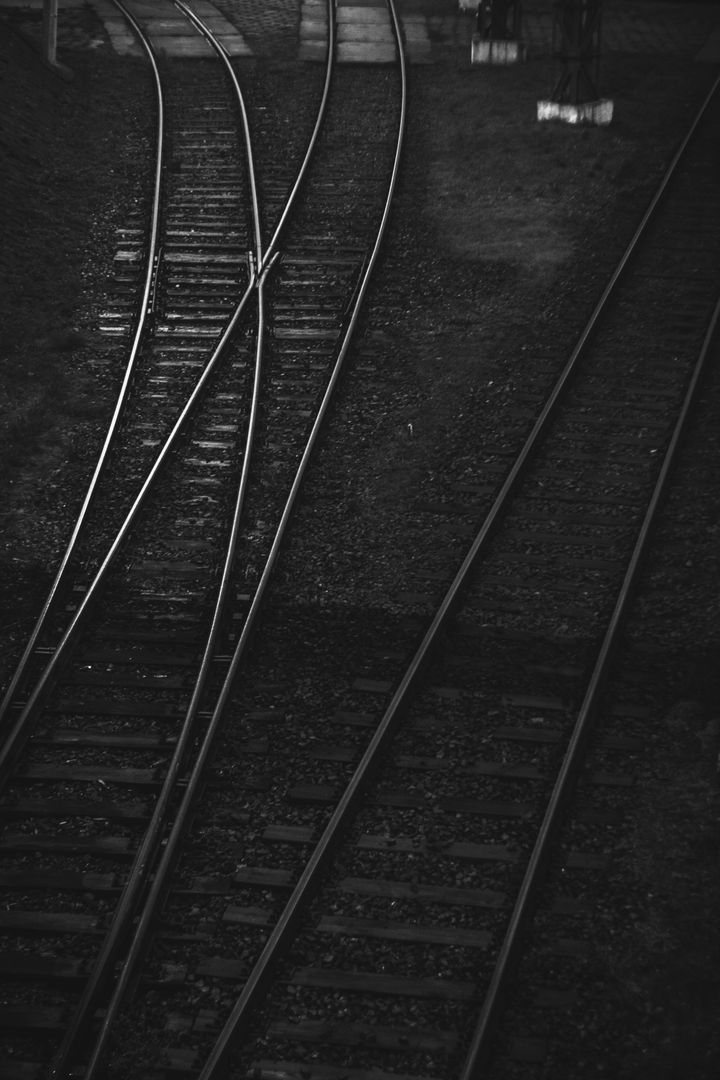Dimly Lit Converging Railroad Tracks in Black and White - Free Images, Stock Photos and Pictures on Pikwizard.com