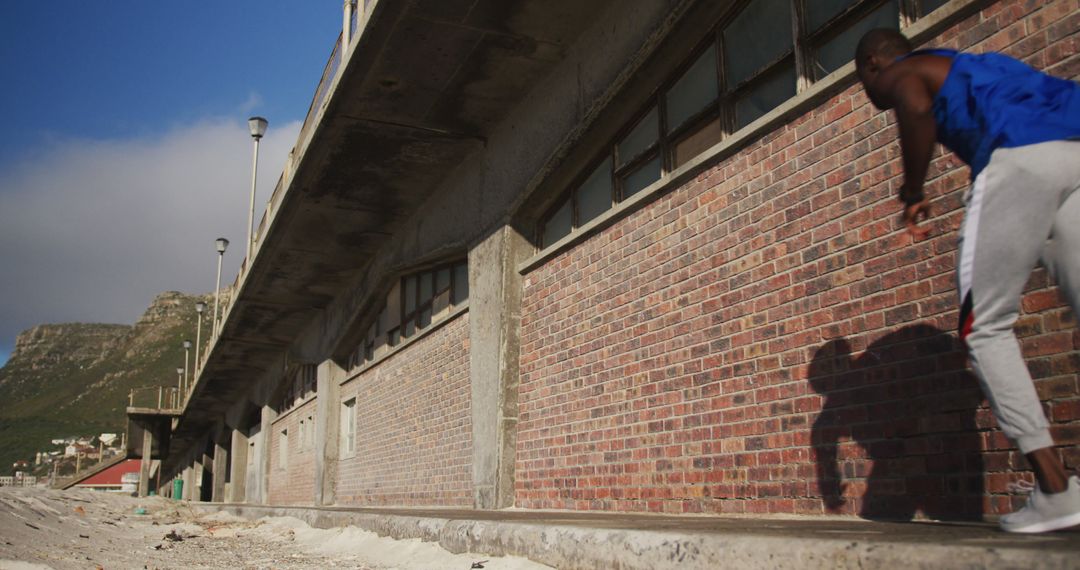 Athlete Performing Parkour Against an Industrial Brick Building - Free Images, Stock Photos and Pictures on Pikwizard.com