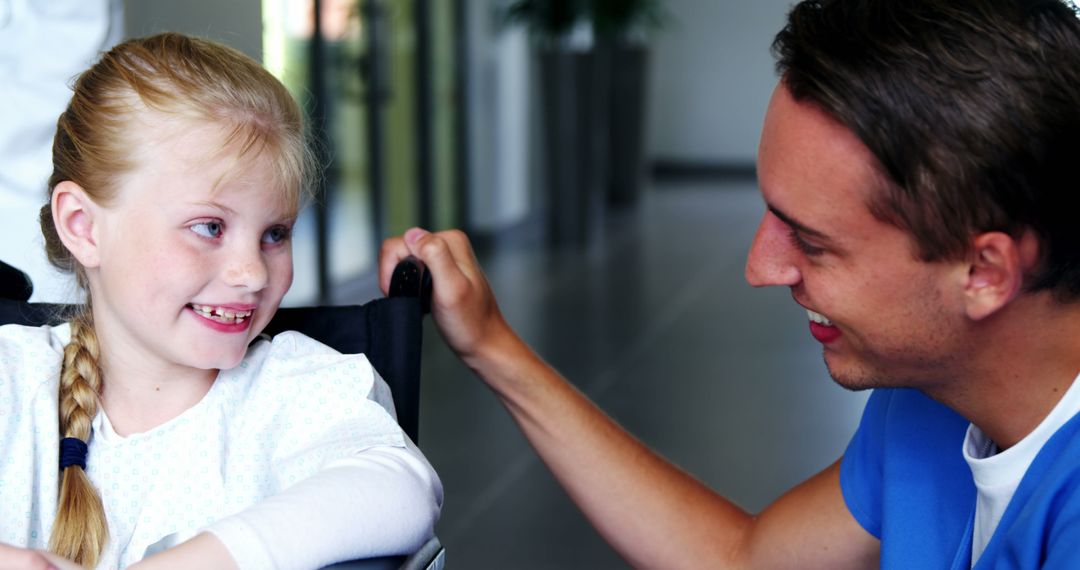 Healthcare Professional Comforting Smiling Girl in Wheelchair - Free Images, Stock Photos and Pictures on Pikwizard.com