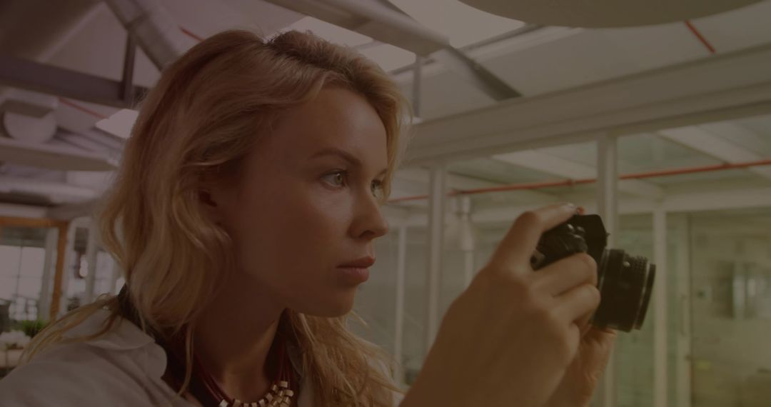 Creative Woman Focusing with Camera in Modern Studio Environment