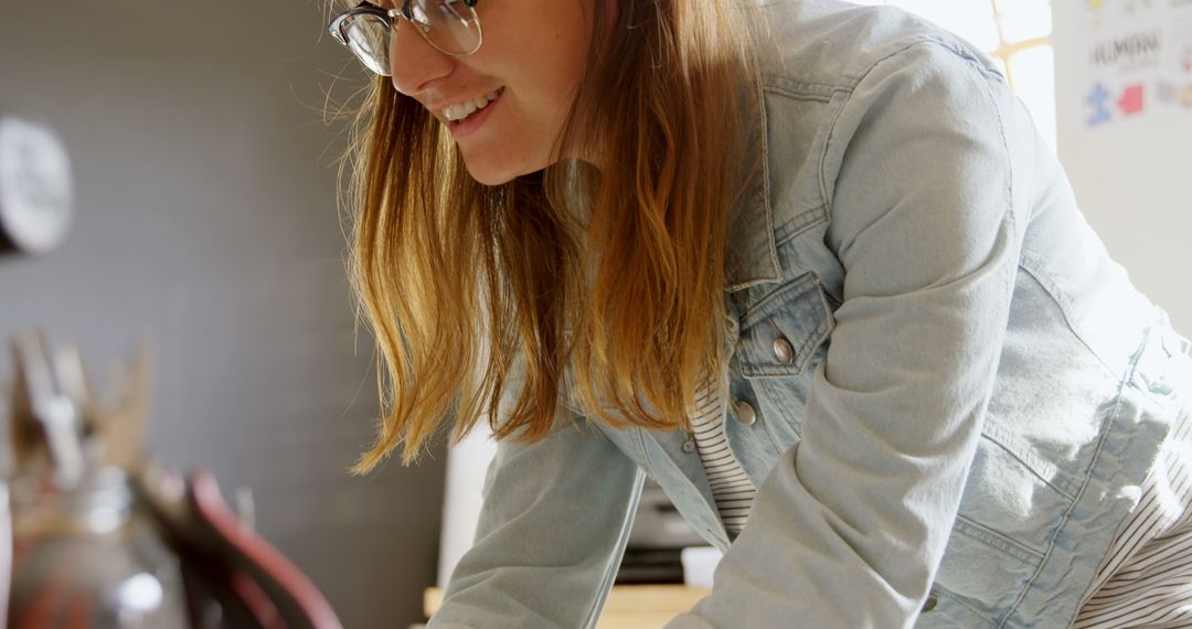 Smiling Woman Wearing Glasses Working in Creative Workspace - Free Images, Stock Photos and Pictures on Pikwizard.com