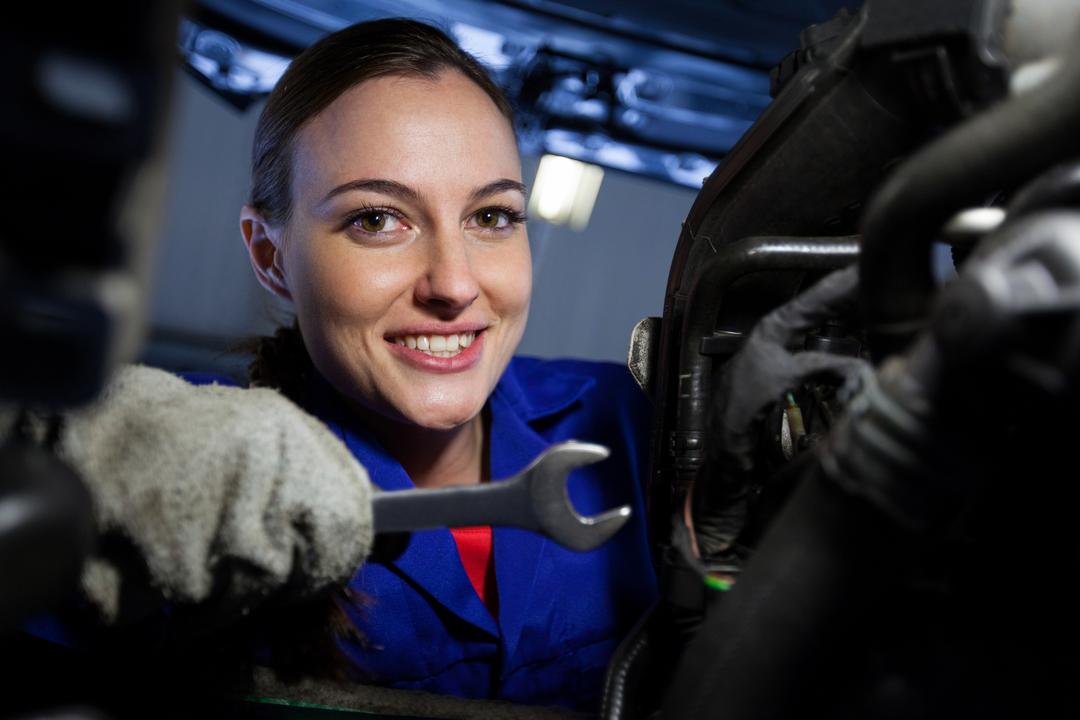 Portrait of female mechanic examining car engine - Free Images, Stock Photos and Pictures on Pikwizard.com
