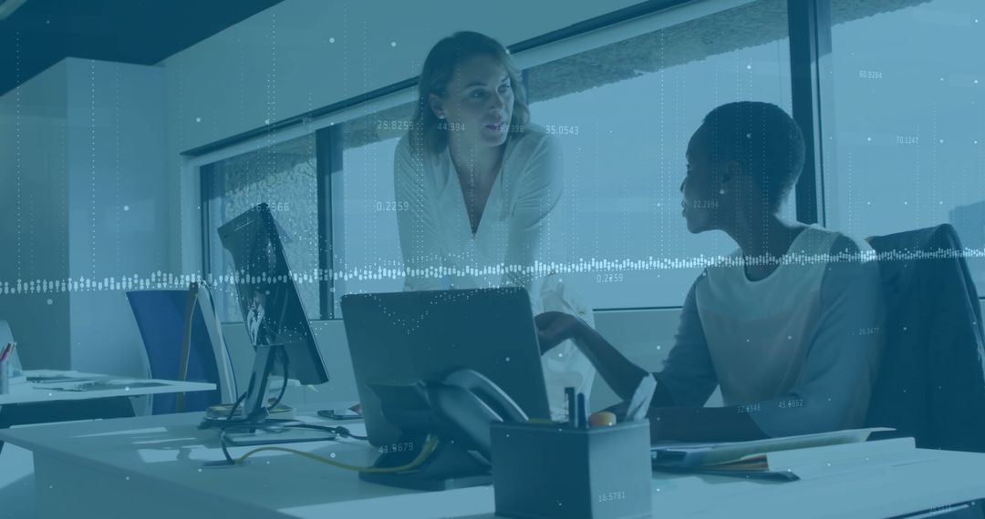 Colleagues Collaborating Over Laptop in Office Workspace