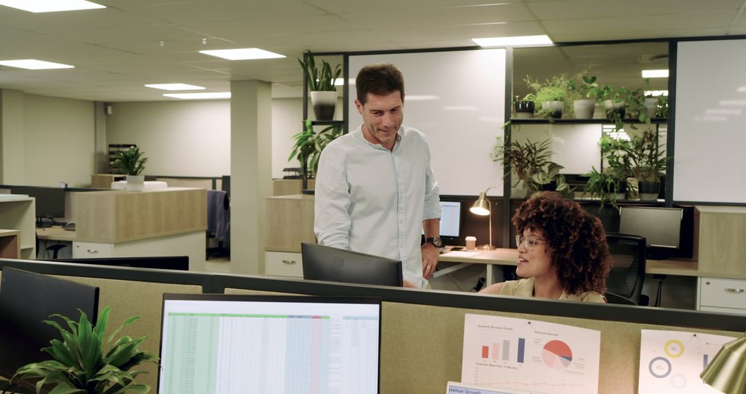 Coworkers Collaborating in Modern Office with Technology and Greenery