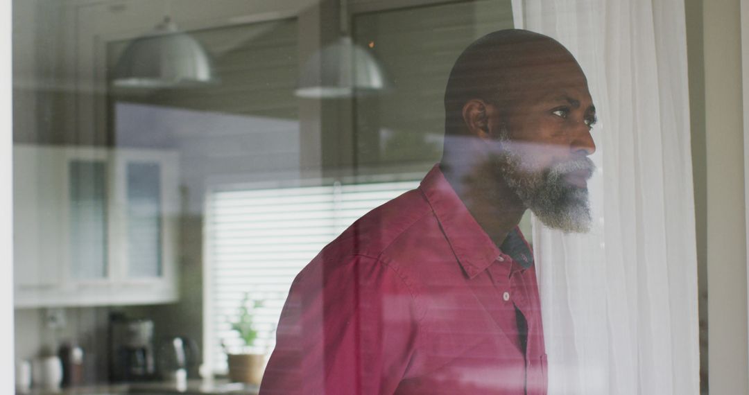 Middle Aged Man Looking Thoughtfully Through Window at Home - Free Images, Stock Photos and Pictures on Pikwizard.com