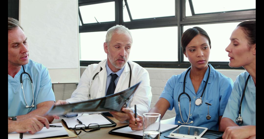 Medical Professionals Discussing Patient X-Ray Results in Team Meeting - Free Images, Stock Photos and Pictures on Pikwizard.com