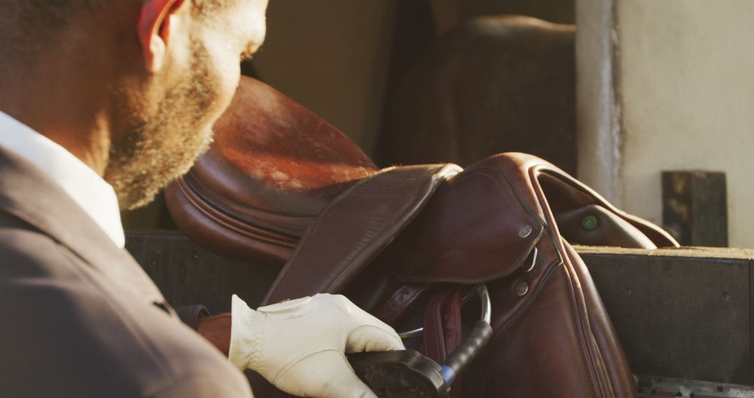 Man Preparing Equestrian Equipment in Stable - Free Images, Stock Photos and Pictures on Pikwizard.com