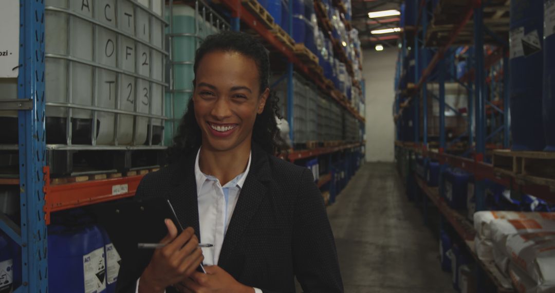 Professional Woman Smiling and Holding Clipboard in a Work Warehouse - Free Images, Stock Photos and Pictures on Pikwizard.com