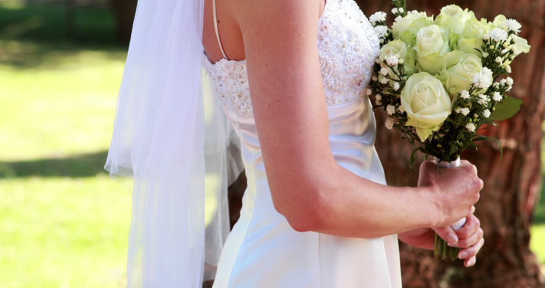 Bride Holding Bouqet in Sunlit Garden - Free Images, Stock Photos and Pictures on Pikwizard.com