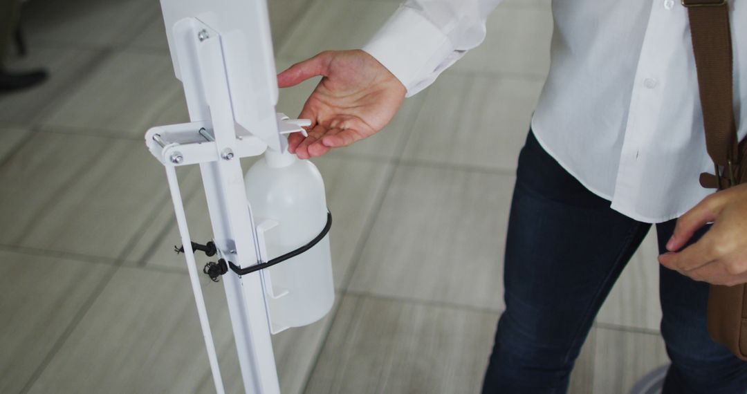 Person Using Hand Sanitizer Dispenser in Public Space - Free Images, Stock Photos and Pictures on Pikwizard.com