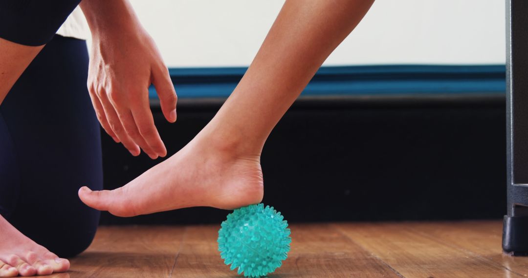 A person is using a textured massage ball to relieve tension in their foot, with copy space - Free Images, Stock Photos and Pictures on Pikwizard.com