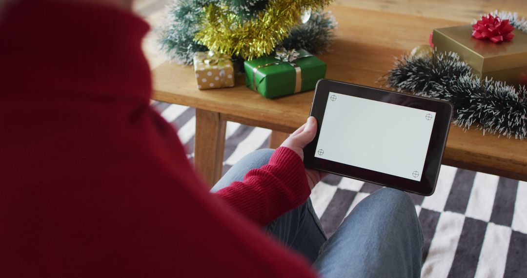 Person using digital tablet during Christmas holiday season - Free Images, Stock Photos and Pictures on Pikwizard.com