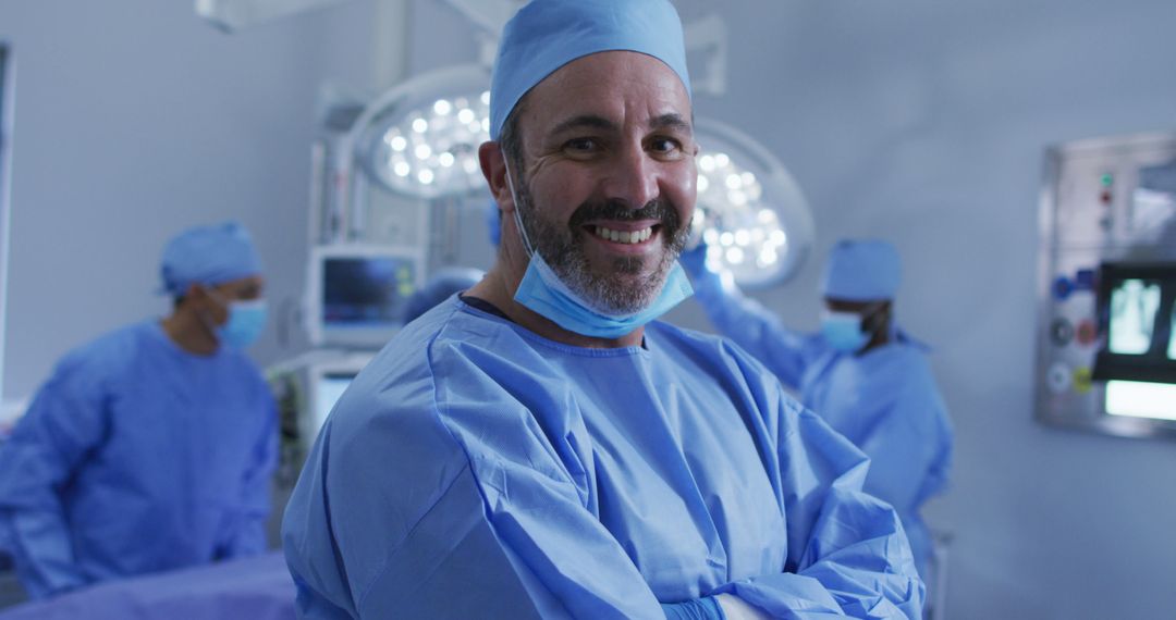 Portrait of caucasian male surgeon standing in operating theatre smiling to camera - Free Images, Stock Photos and Pictures on Pikwizard.com