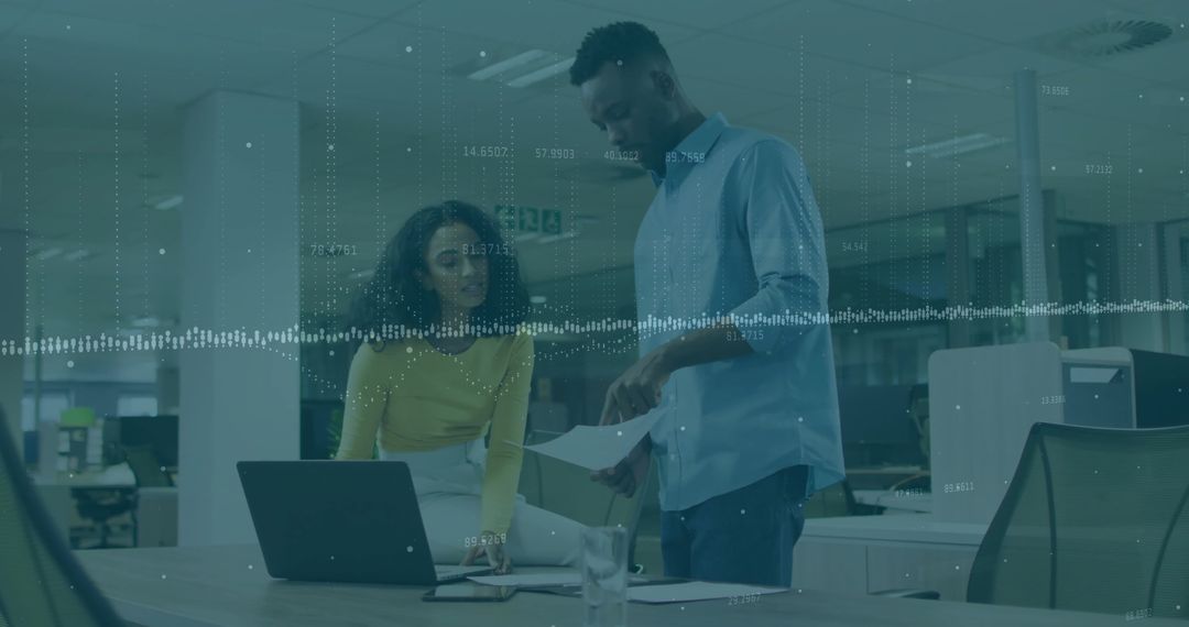 Office Colleagues Collaborating on Business Documents with Laptop