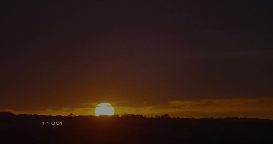 Tranquil Sunset Over Rural Hills with Silhouetted Shrubbery