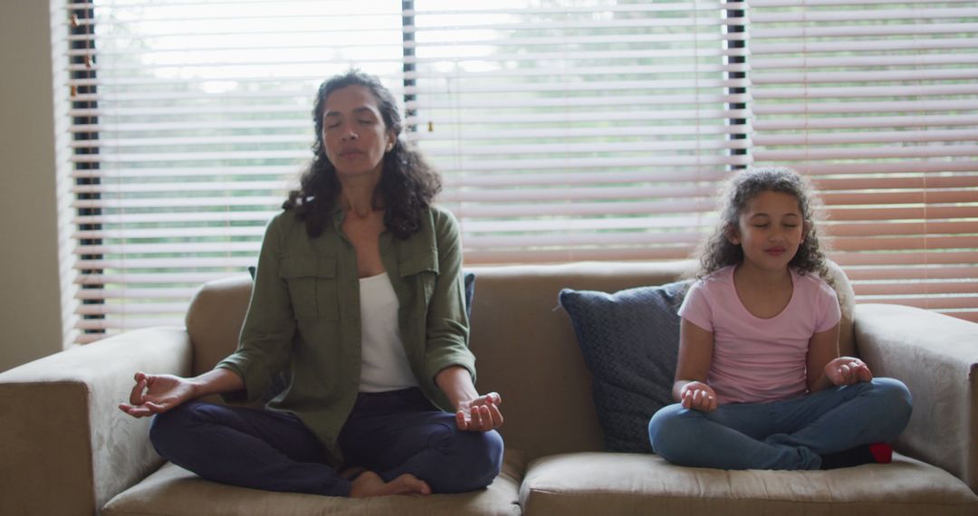 Mother and Daughter Meditating on Sofa Together Relaxing - Free Images, Stock Photos and Pictures on Pikwizard.com