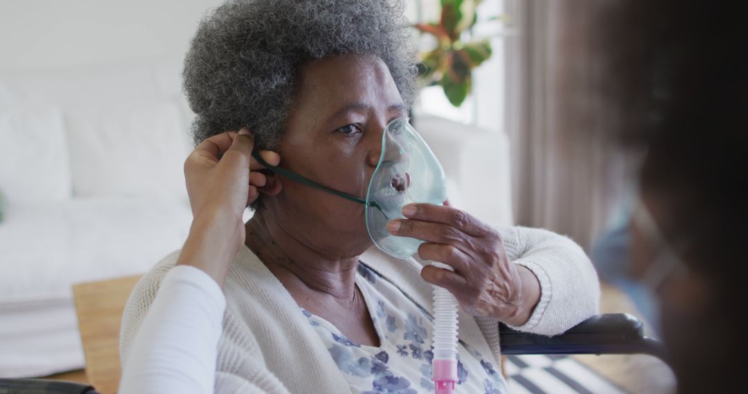 Healthcare worker assisting senior woman with oxygen mask at home - Free Images, Stock Photos and Pictures on Pikwizard.com