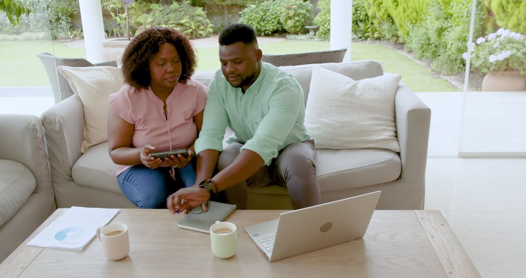 Couple Managing Finances at Home Using Digital Devices