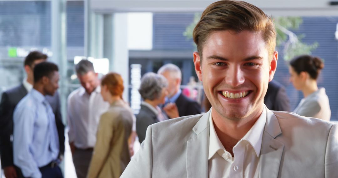 Smiling Confident Businessman in Office with Colleagues in Background - Free Images, Stock Photos and Pictures on Pikwizard.com