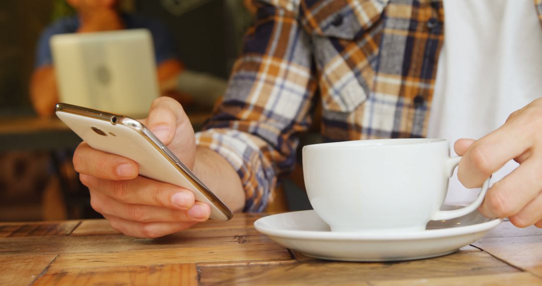 Person Relaxing in Coffee Shop Browsing Smartphone - Free Images, Stock Photos and Pictures on Pikwizard.com