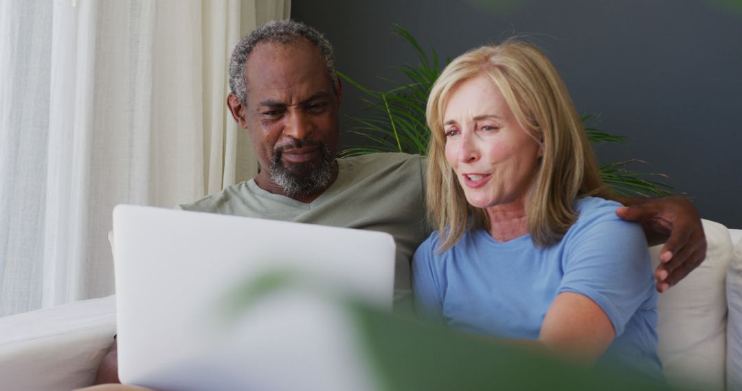 Senior Couple Enjoying Time Together on Couch with Laptop
