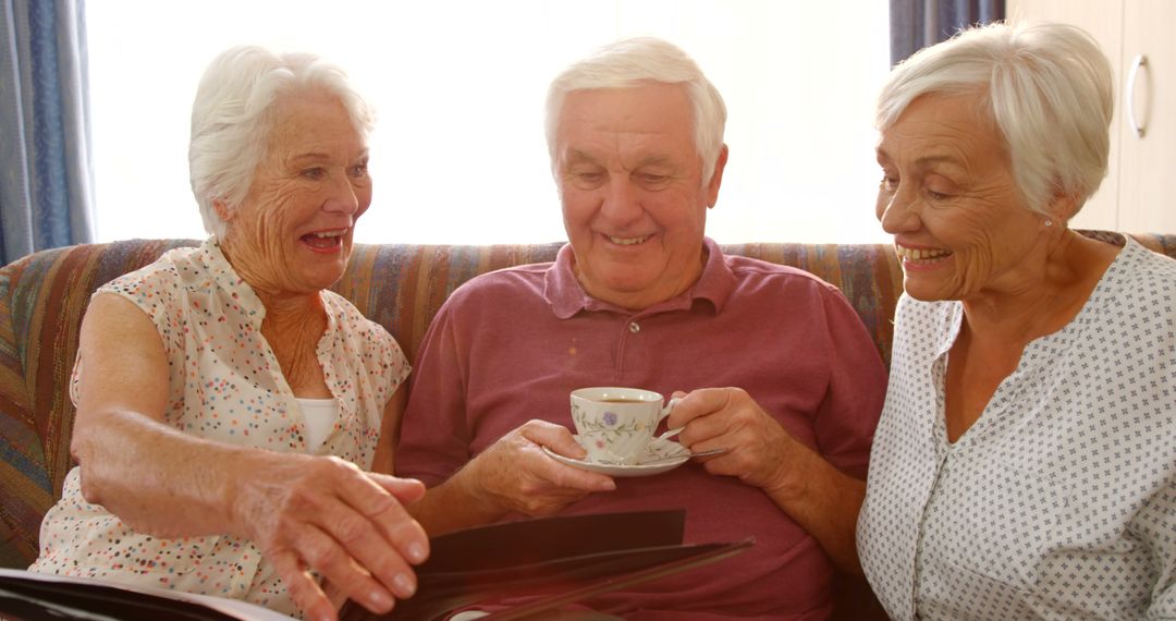 Senior Friends Enjoying Tea and Photo Album Together - Free Images, Stock Photos and Pictures on Pikwizard.com