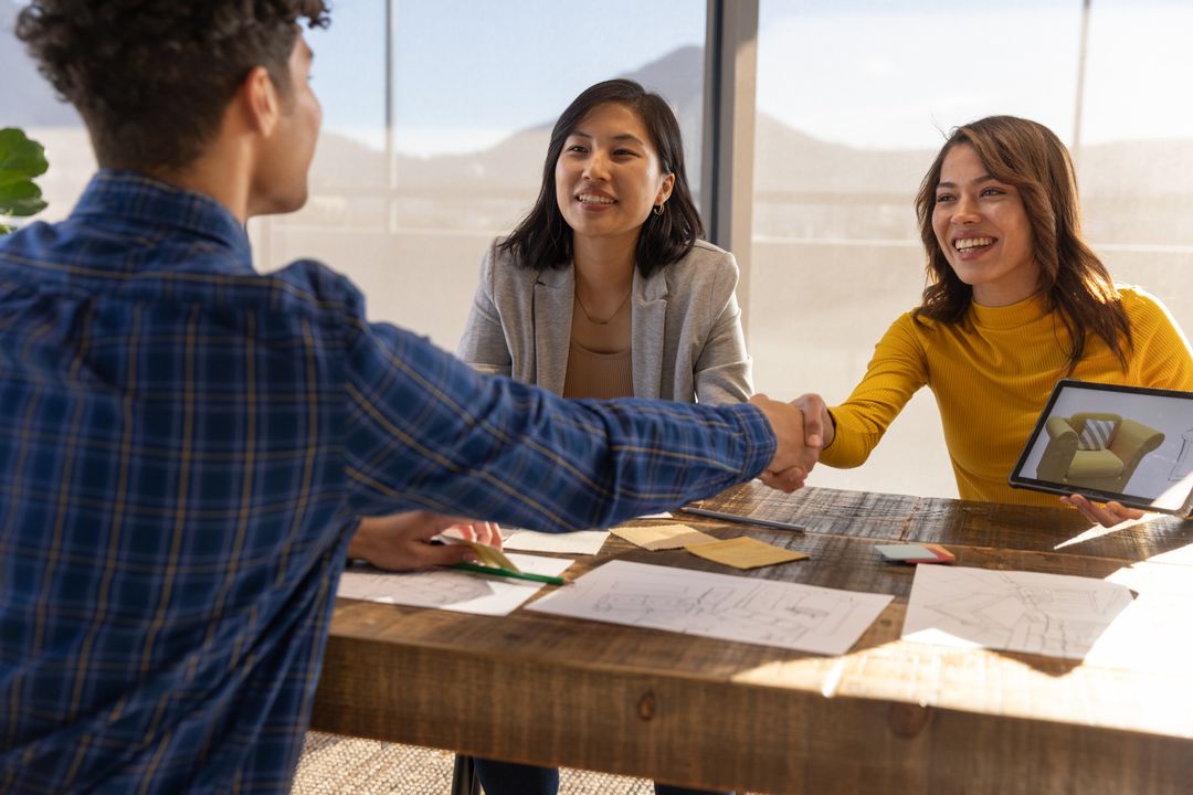 Diverse Colleagues Shaking Hands in Creative Office Meeting