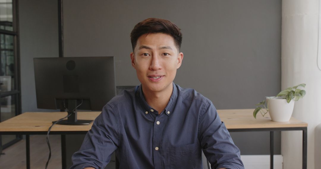 Businessman Smiling Calmly While Seated at Desk in Office