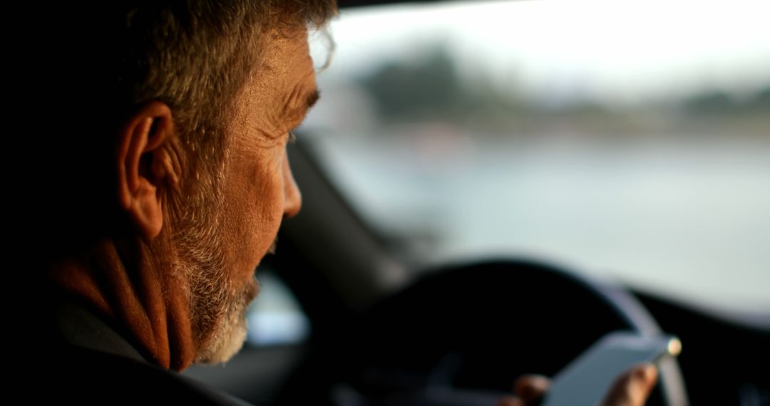 Mature Man Driving Car Using Smartphone GPS for Navigation - Free Images, Stock Photos and Pictures on Pikwizard.com