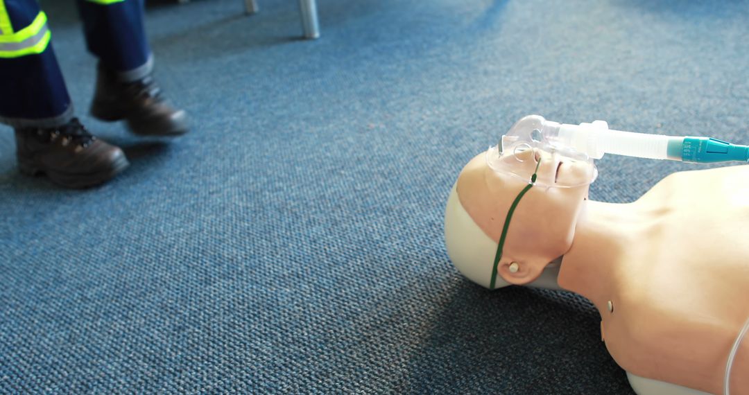 CPR Training Mannequin with Oxygen Mask on Office Floor - Free Images, Stock Photos and Pictures on Pikwizard.com