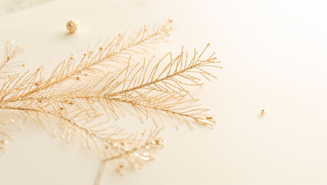 Glittering Gold Branch Resting on Cream Surface Minimalist Holiday Flatlay with Beads