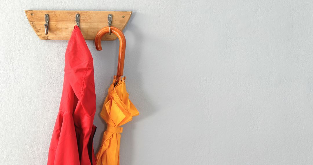 Red Jacket and Orange Umbrella Hanging on Rustic Wooden Hook - Free Images, Stock Photos and Pictures on Pikwizard.com