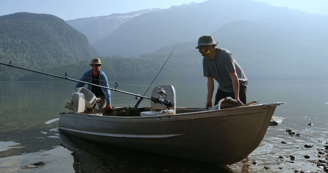 Two middle-aged Caucasian men are preparing for a fishing trip on a serene lake, with copy space - Free Images, Stock Photos and Pictures on Pikwizard.com