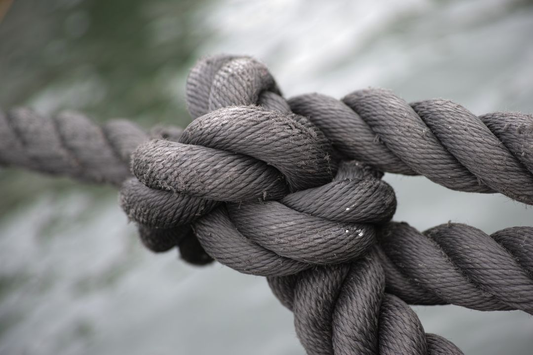 Close-Up of Thick Marine Rope Tied in Strong Knot Over Water - Free Images, Stock Photos and Pictures on Pikwizard.com