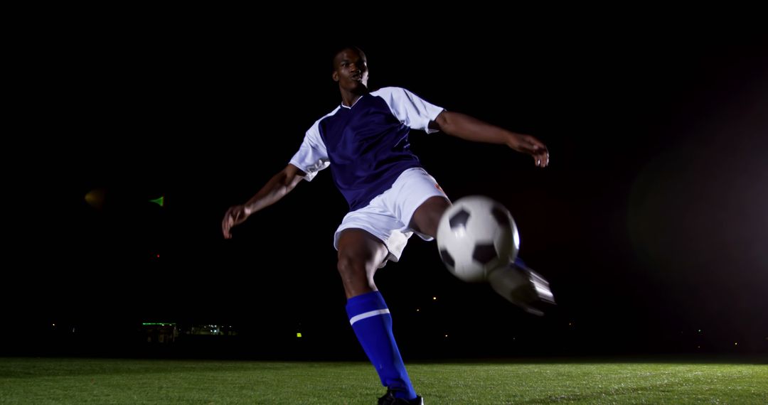 Soccer Player Kicking Ball at Night on Field - Free Images, Stock Photos and Pictures on Pikwizard.com