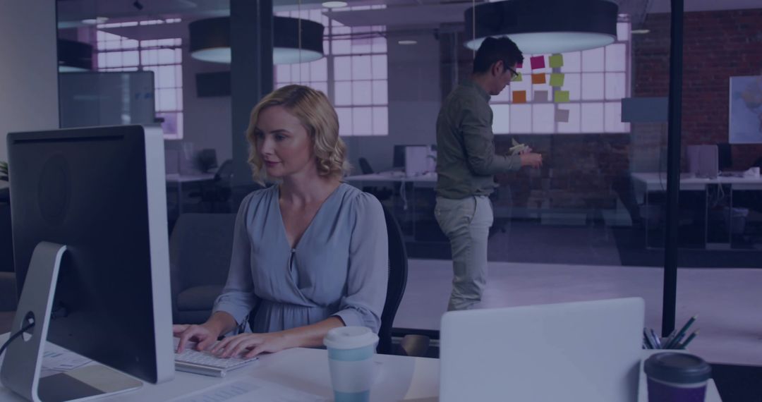 Modern Office Setting with Woman Typing at Workstation