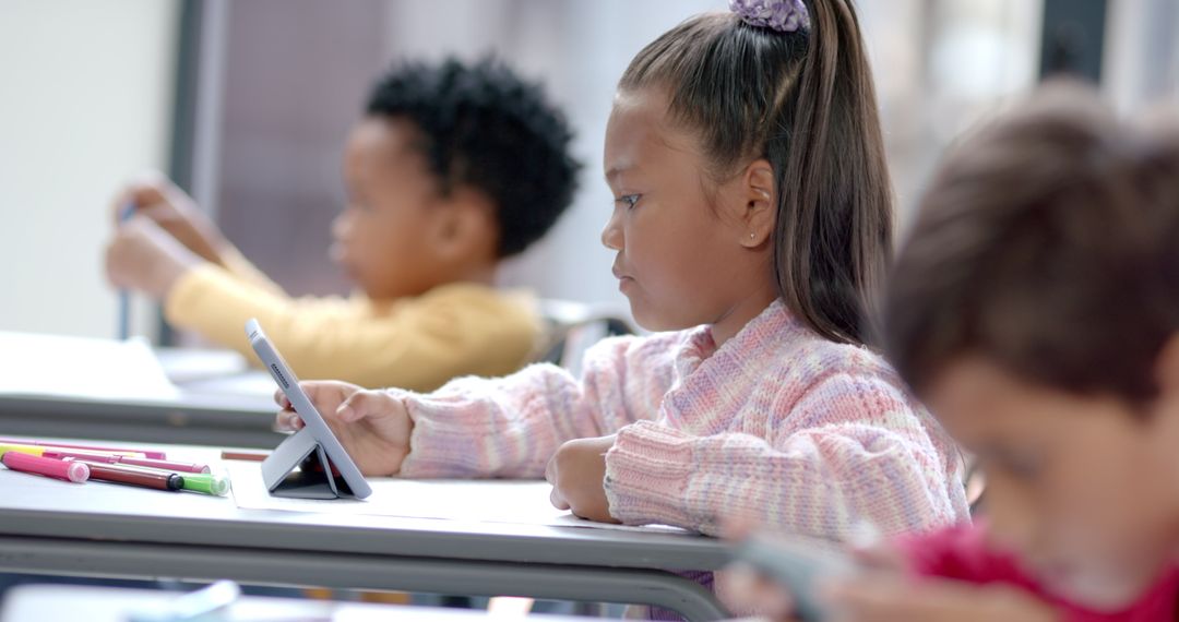Focused Children Using Tablets in Modern Classroom Learning Environment
