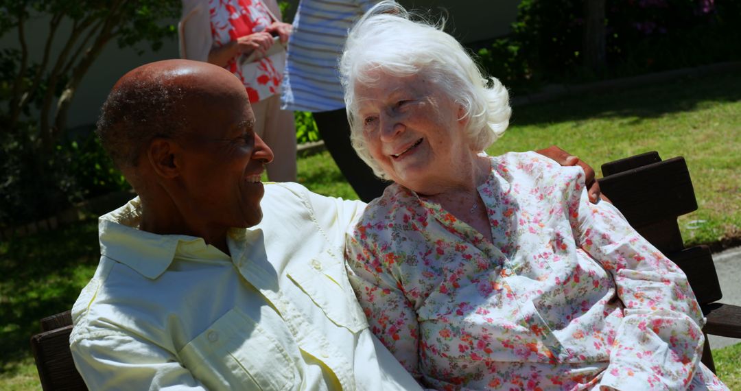 Smiling Senior Couple Relaxing in Nursing Home Garden