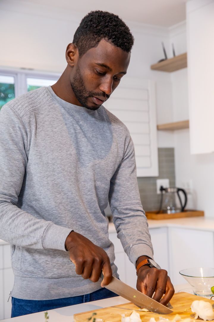 Man Preparing Fresh Cauliflower in Modern Kitchen Setting