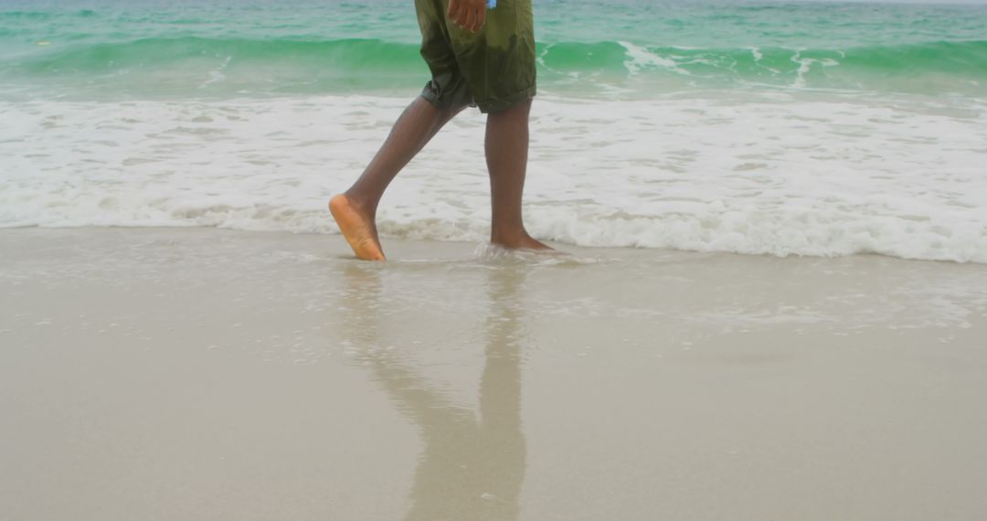 Man Enjoying Sea Foam at Sandy Beach